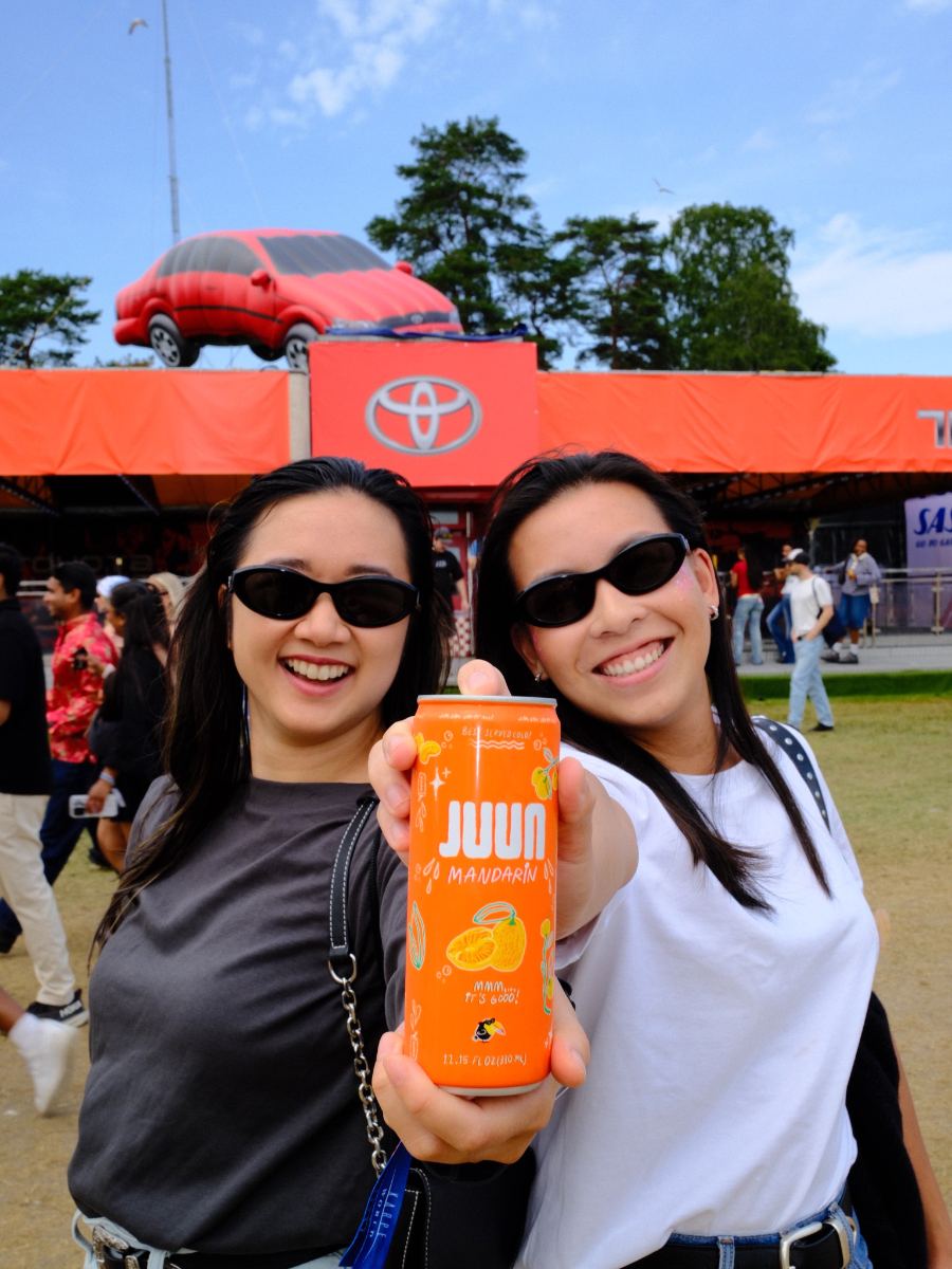 Two friends in sunglasses holding a mandarin JUUN can